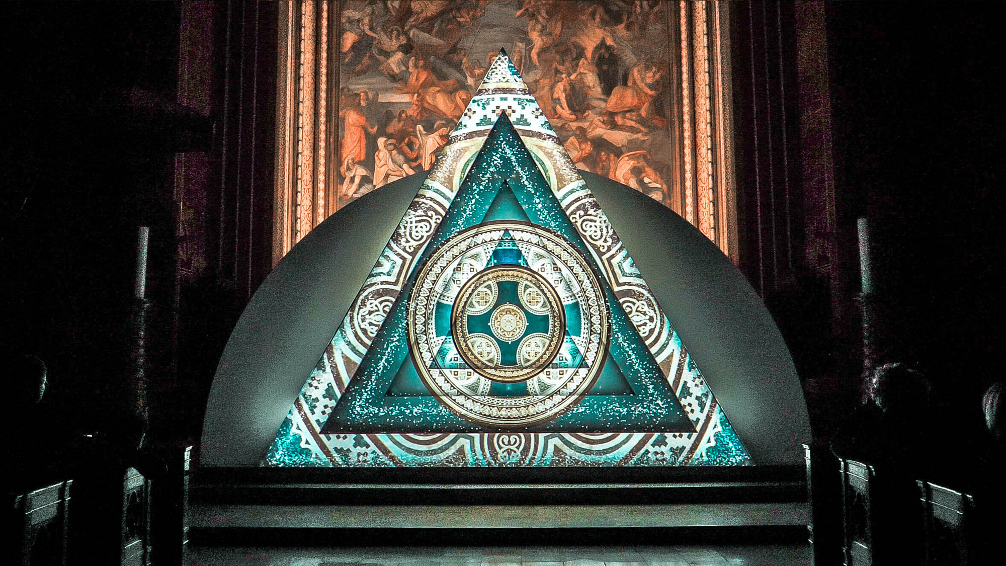 Image of a video art installation. Triangle with geometric and ornamental design. Light art show in a church