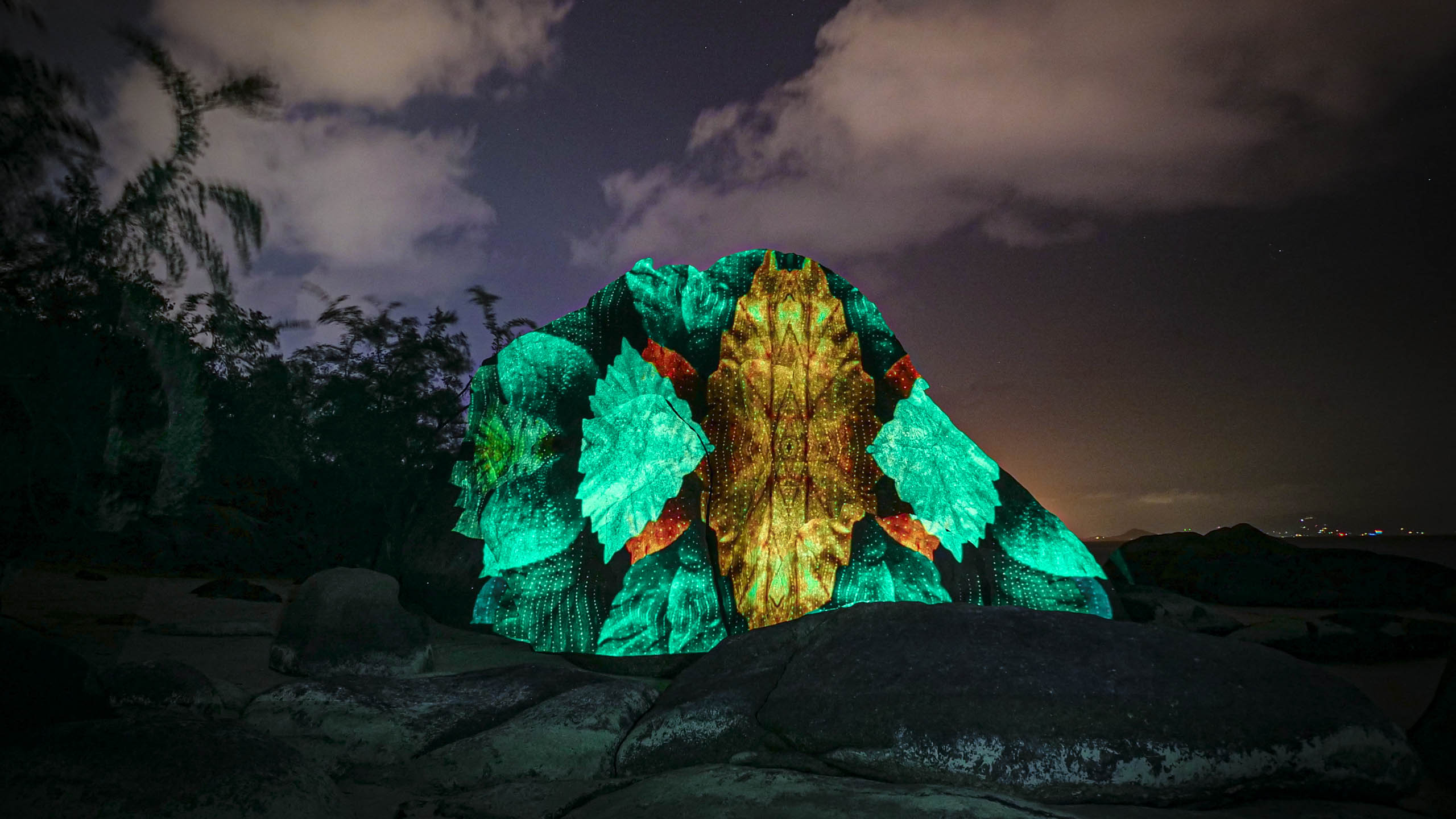 light art, 3d projection mapping with nature elements and green colors by philipp frank. Located on a rock at the beach