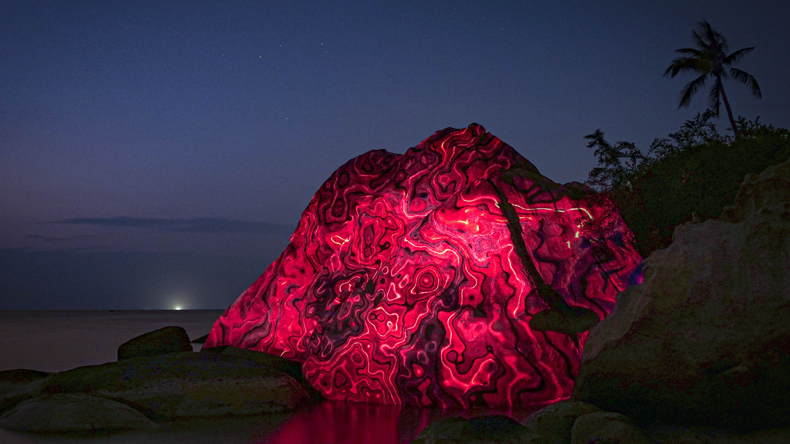 light art, 3d projection mapping on a rock at the beach