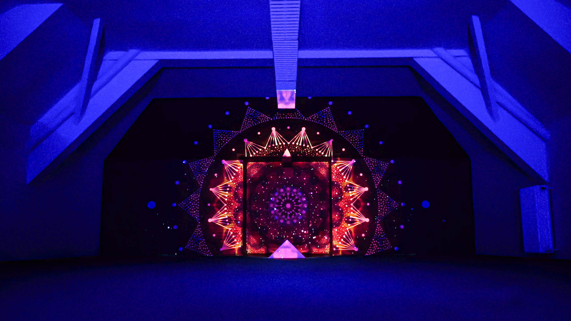 Image of a video art installation combined with a mural painting. Mandala geometric design with projection mapping art.