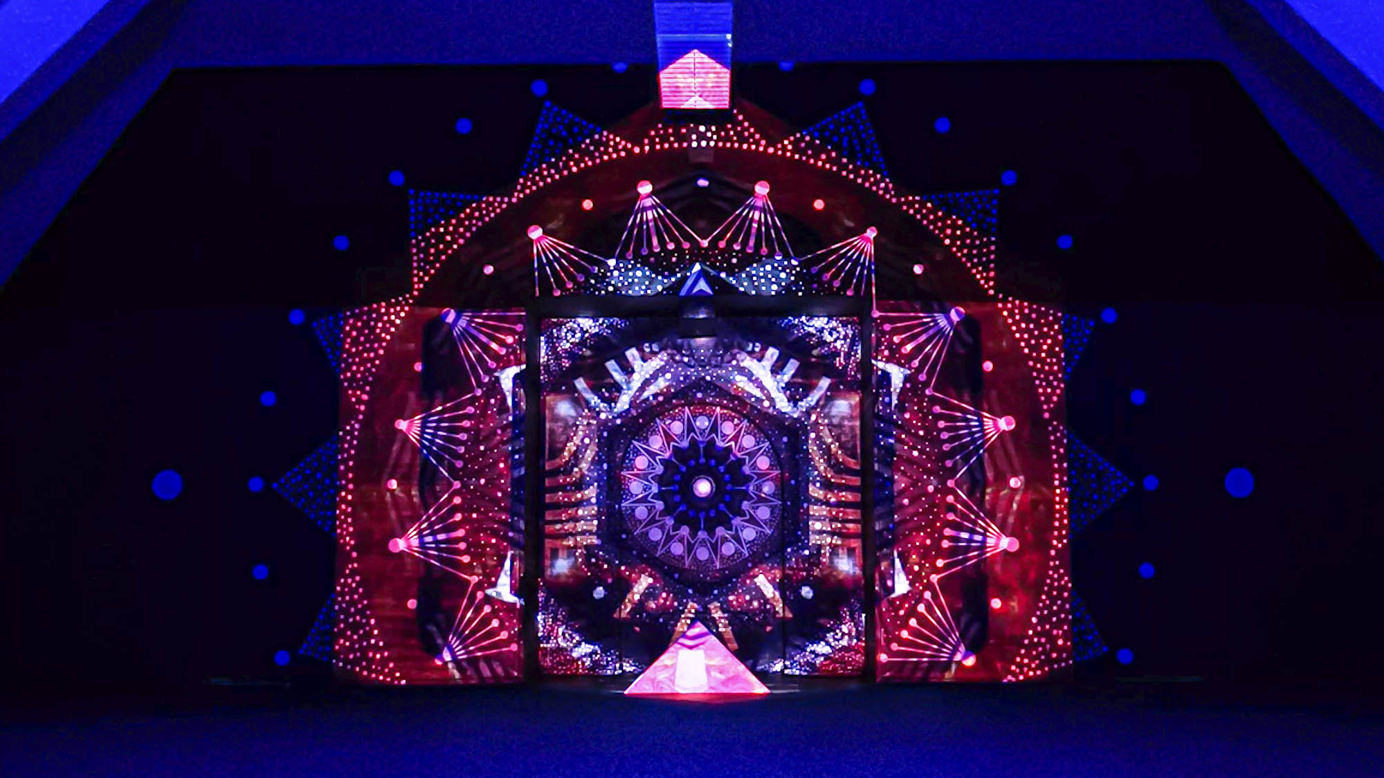 Image of a video art installation combined with a mural painting. Mandala geometric design with projection mapping art. Light artist philipp frank