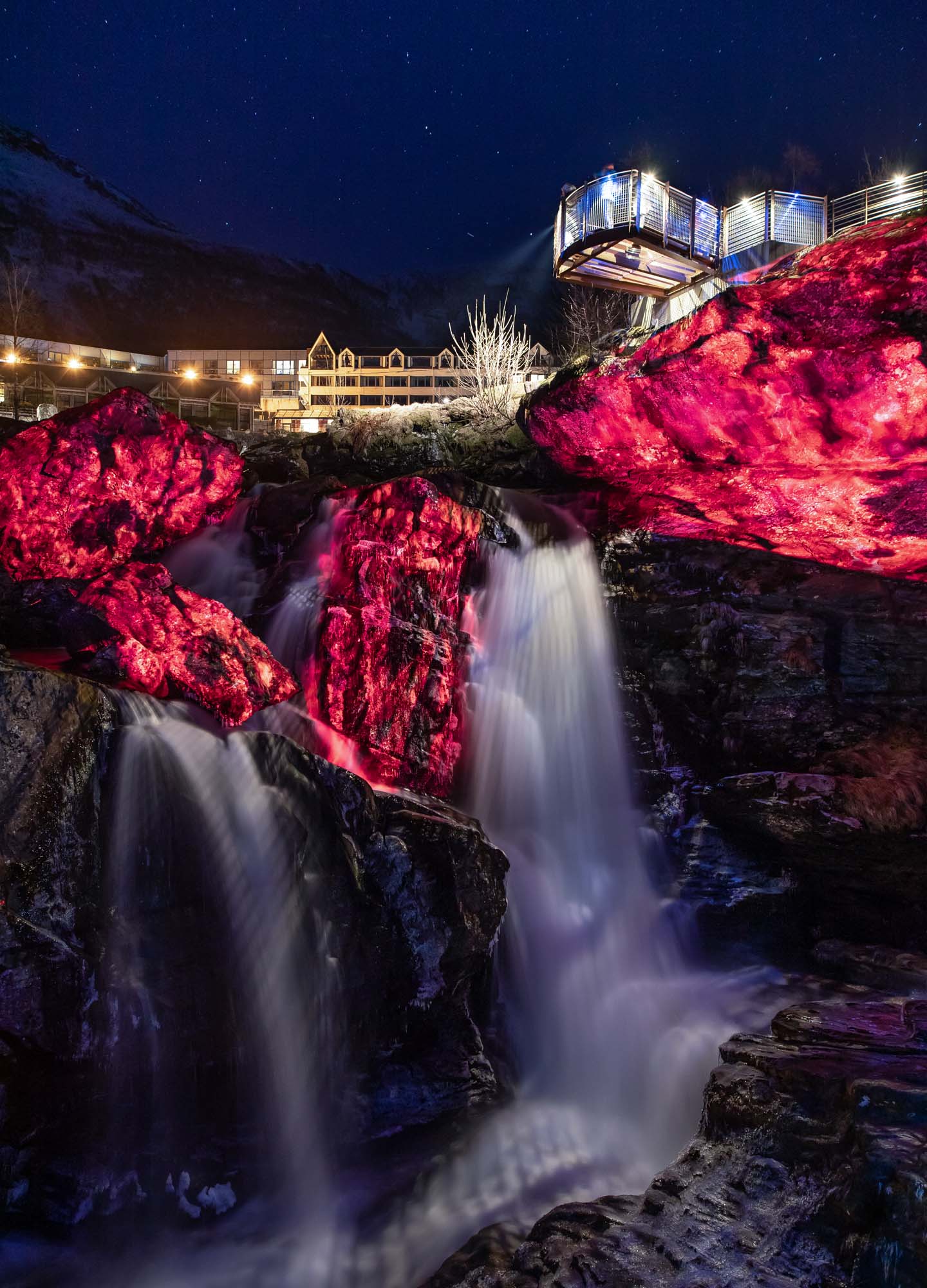 Red lava visuals video projection onto rocks near a waterfall at Geiranger Fjord