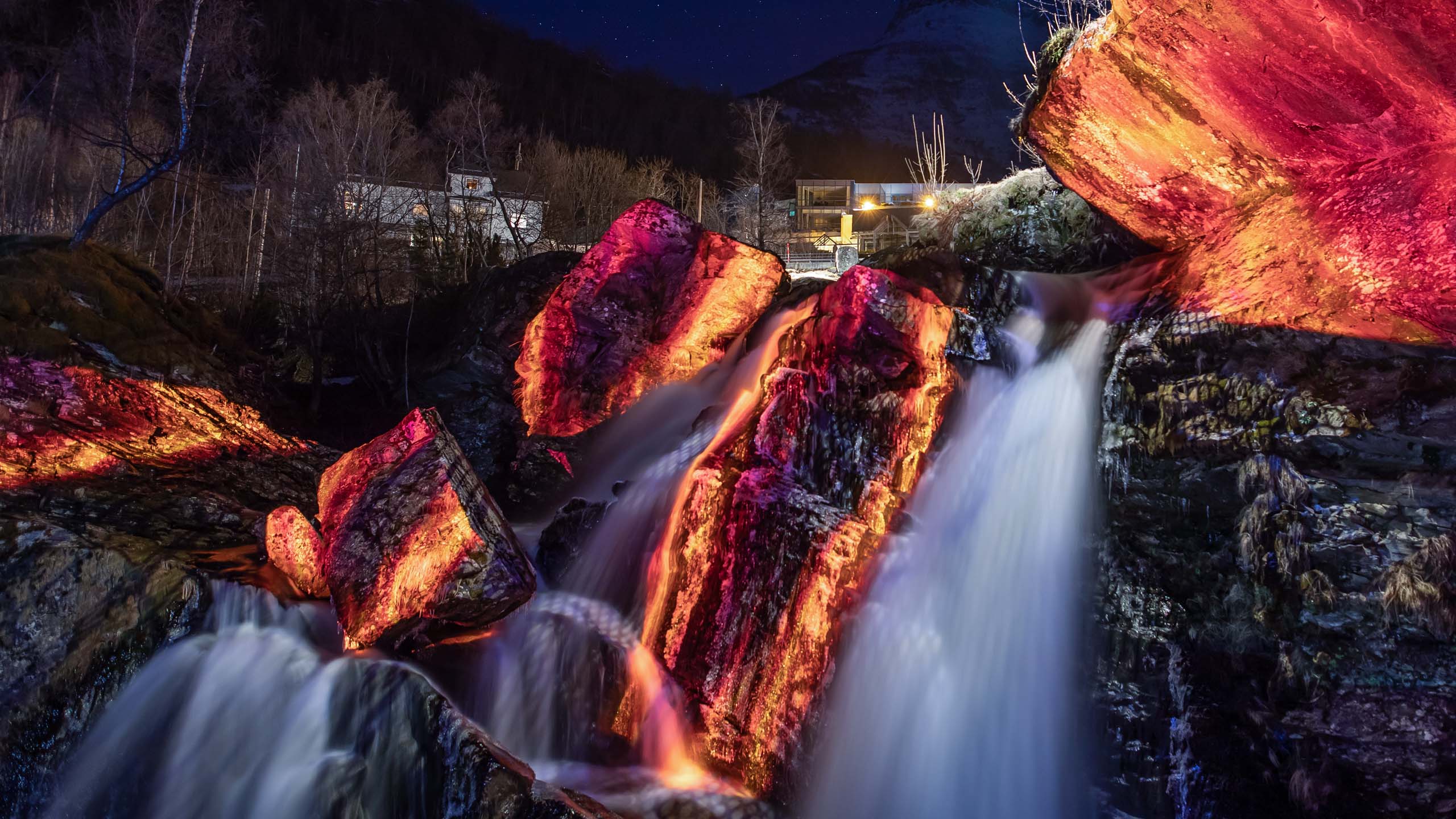 Rocks and a waterfall with a video-mapping installation showing fire and lava visuals