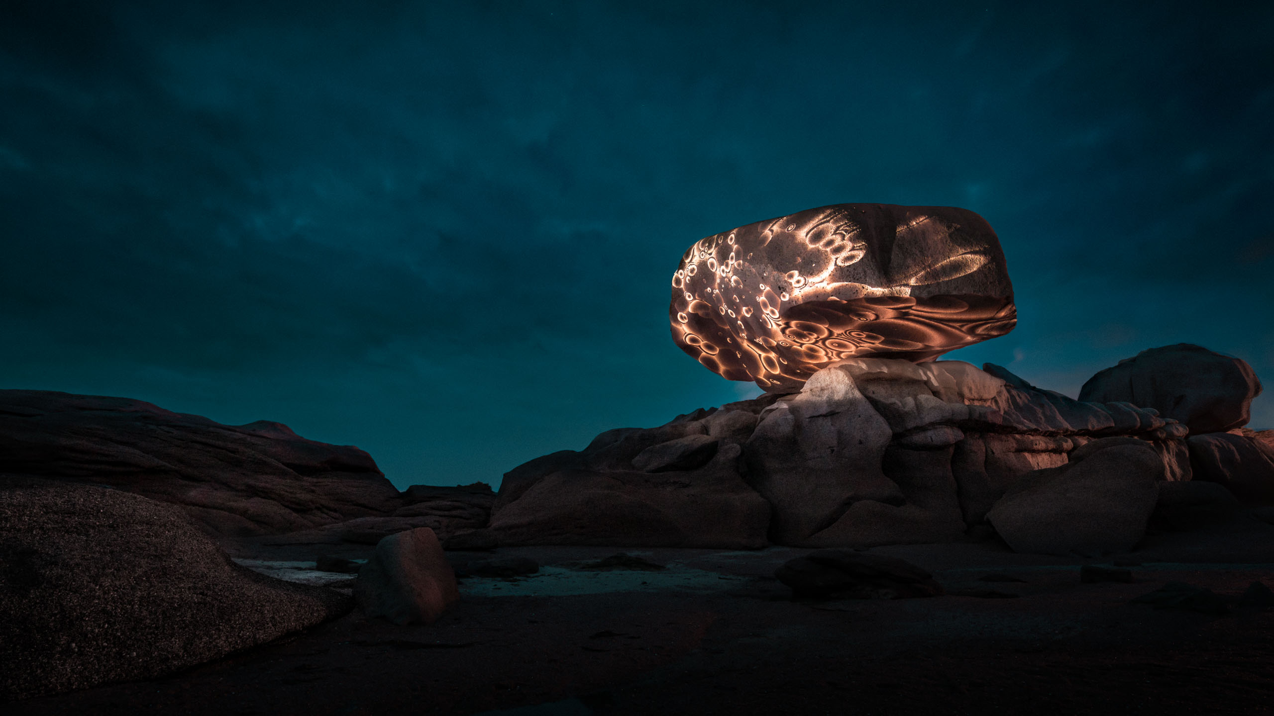 Land-art projection mapping light installation on a rock at Côte de Granit Rose in France