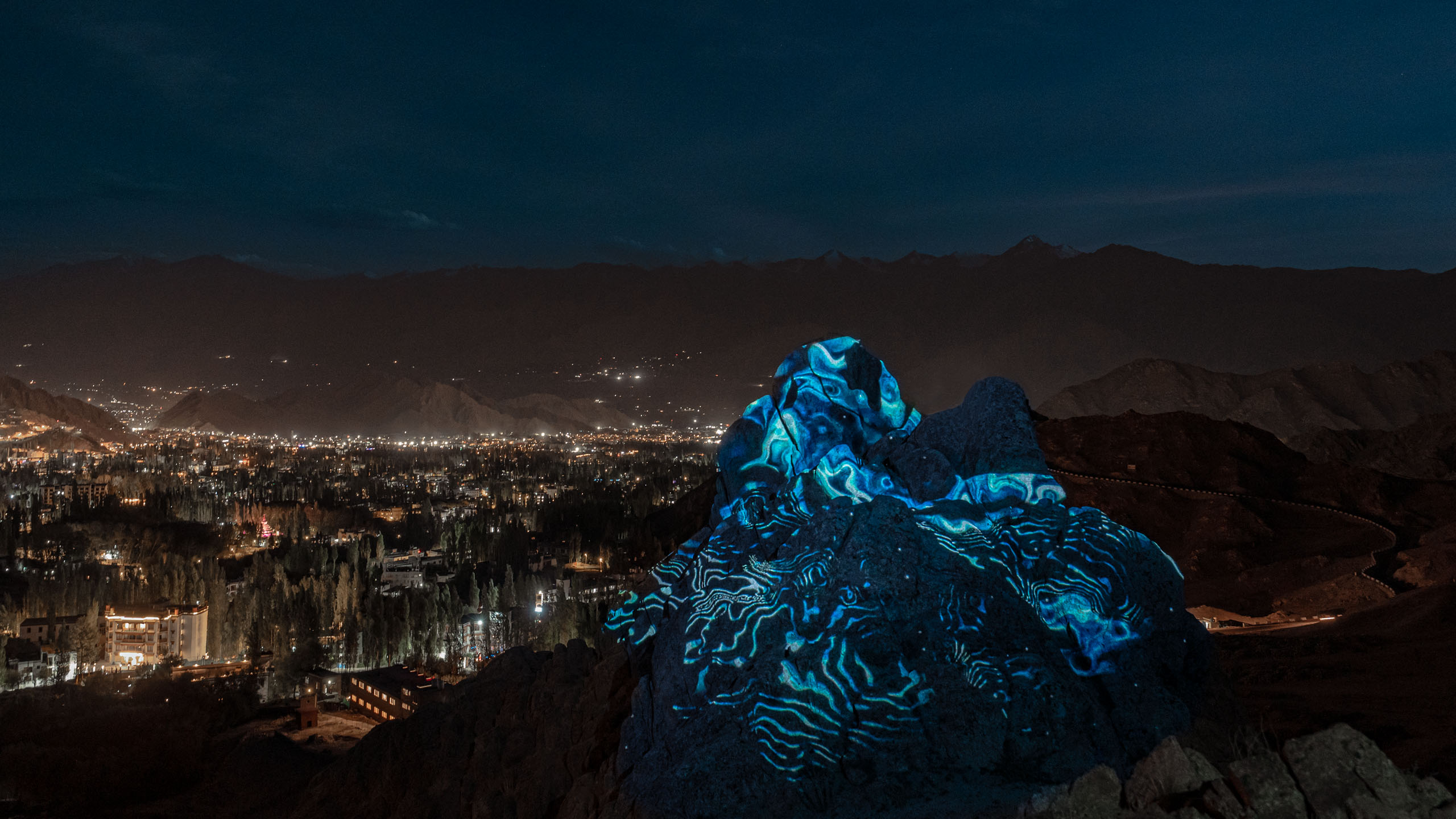 Land art projection mapping show. Blue abstract visuals in the Himalayan landscape 