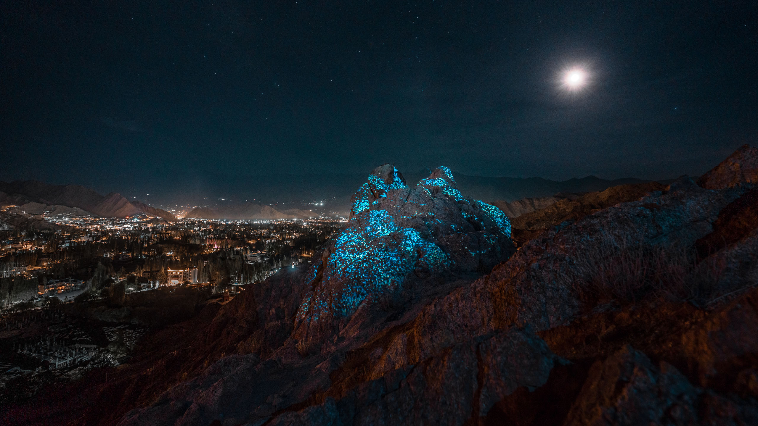 Land art projection mapping artwork on a rock with blue visuals in the Himalaya