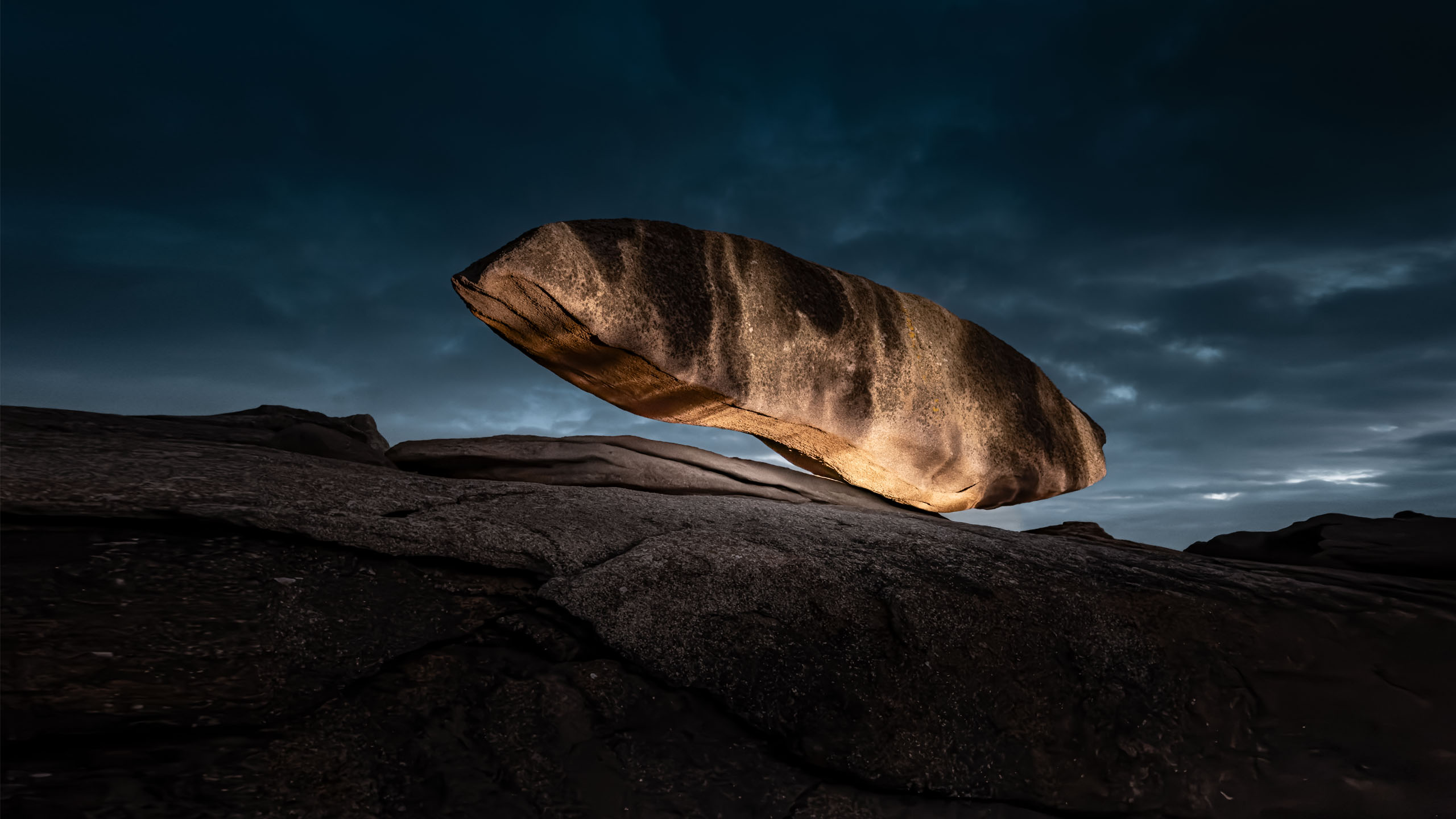 Land-art projection mapping light installation on a floating rock at Côte de Granit Rose in France