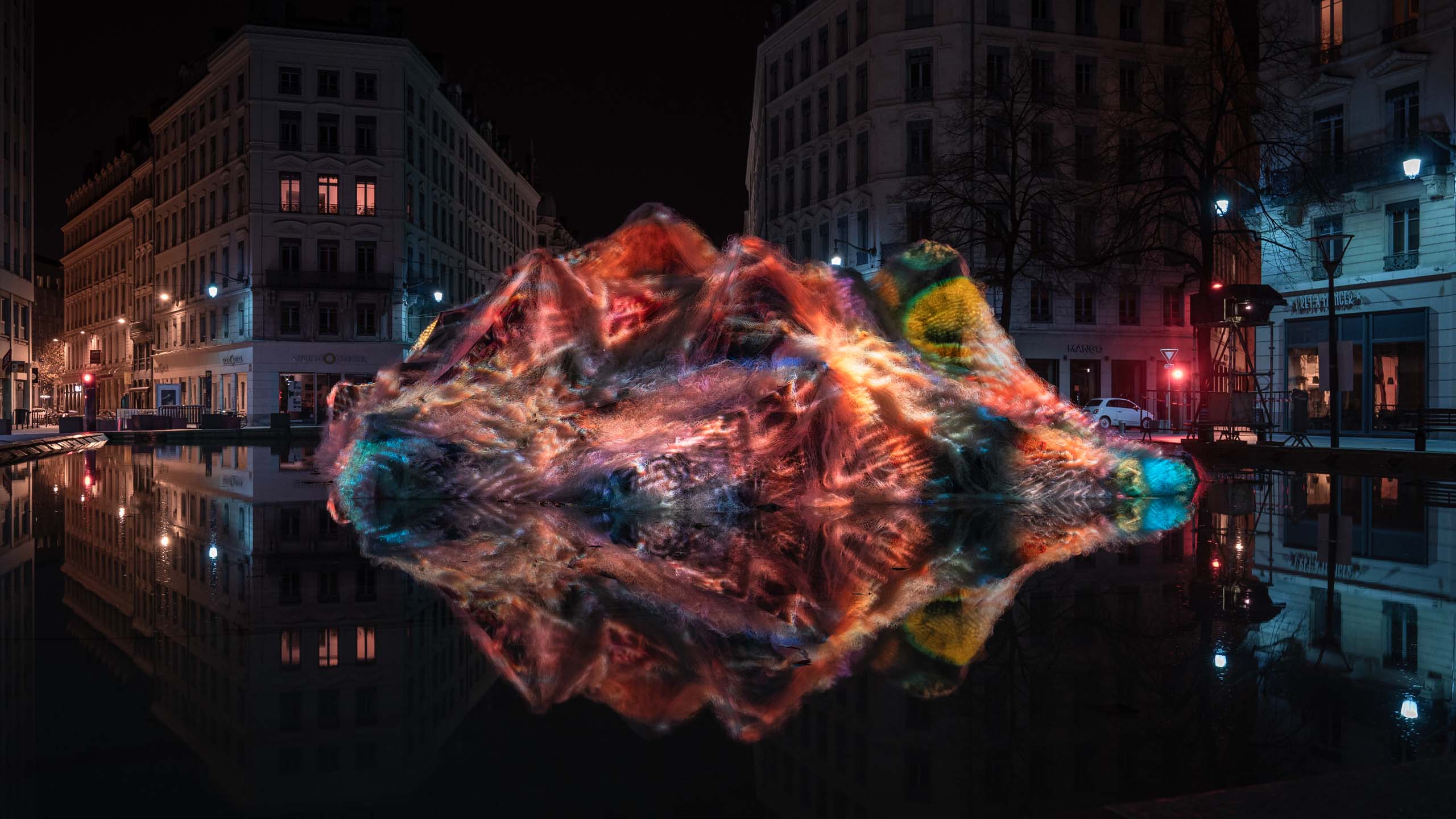 Coral Ghosts Art Installation_Philipp Frank_22 Colorful projection of Coral Ghosts installation by Philipp Frank, transforming recycled ghost nets into a glowing coral-like sculpture at Fête des Lumières in Lyon.