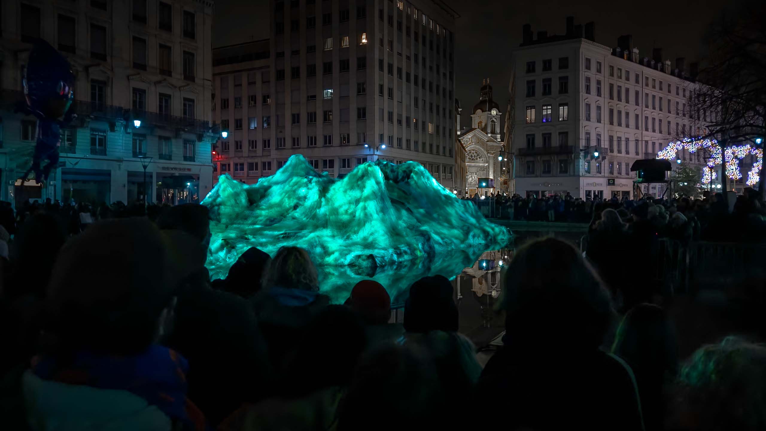 Coral Ghosts Art Installation_Philipp Frank_28 Audience viewing Coral Ghosts light installation by Philipp Frank at Fête des Lumières in Lyon, with glowing green projections on recycled ghost nets.
