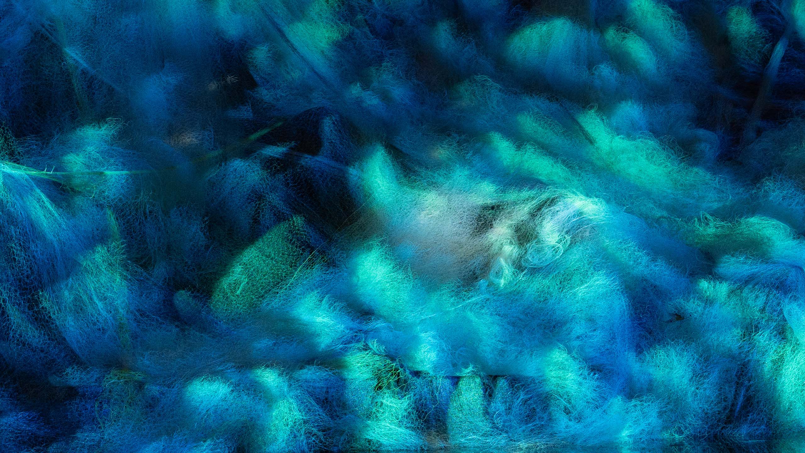 Coral Ghosts Art Installation_Philipp Frank_4 Close-up of glowing recycled ghost nets in Coral Ghosts installation by Philipp Frank, showing vibrant blue and green light textures inspired by coral reefs.