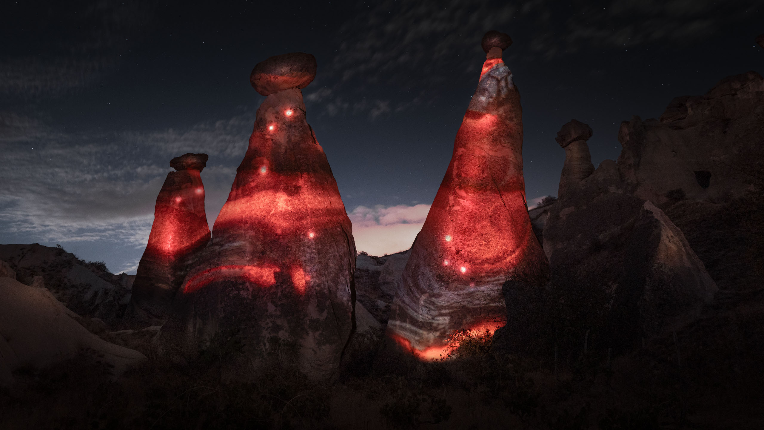 Light projection by Philipp Frank onto the fairy chimneys of Cappadocia – glowing bands of energy illuminate the unique stone formations under a starry night sky.